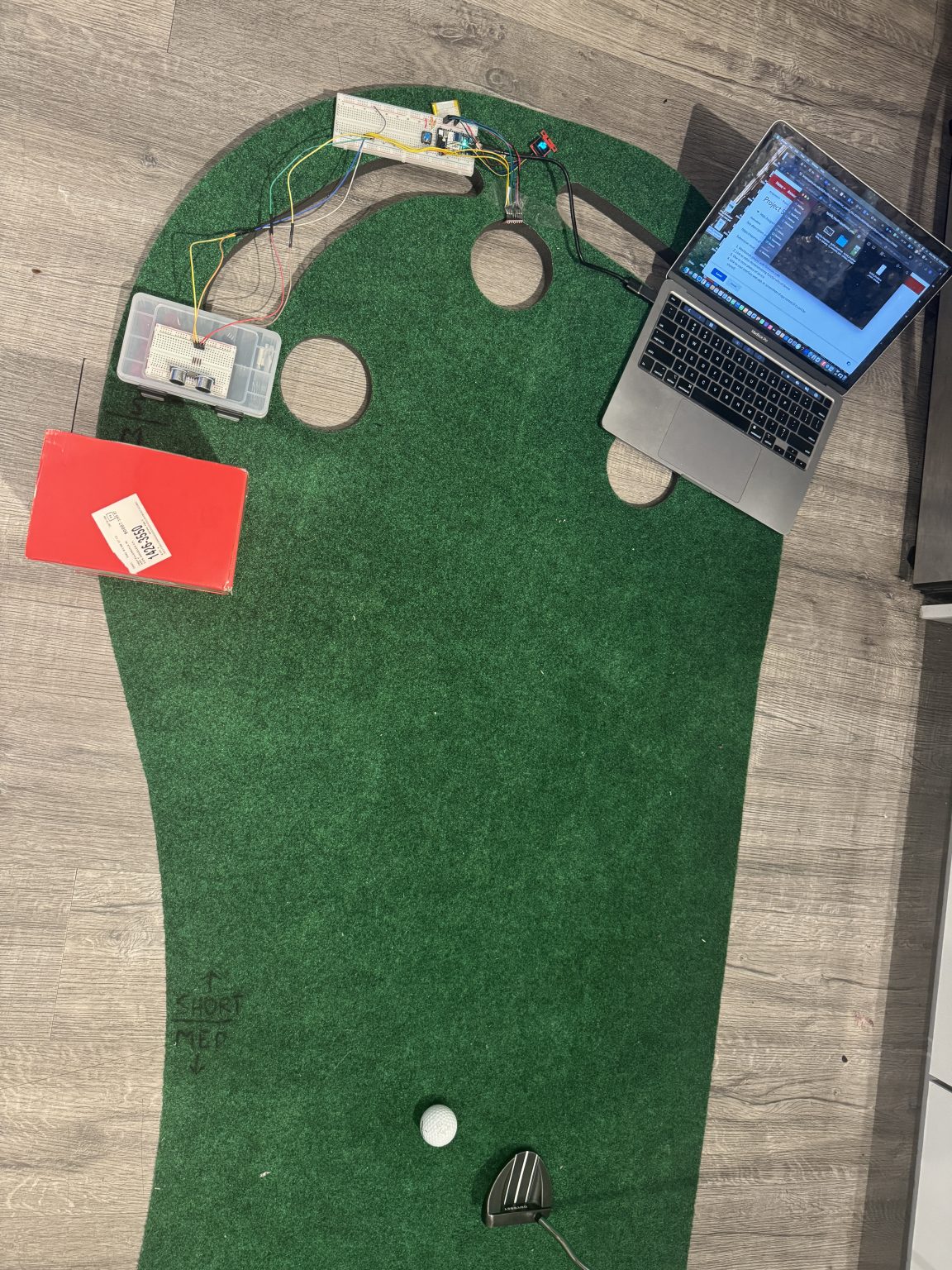 Golf putting game with artificial turf, sensors, and control electronics