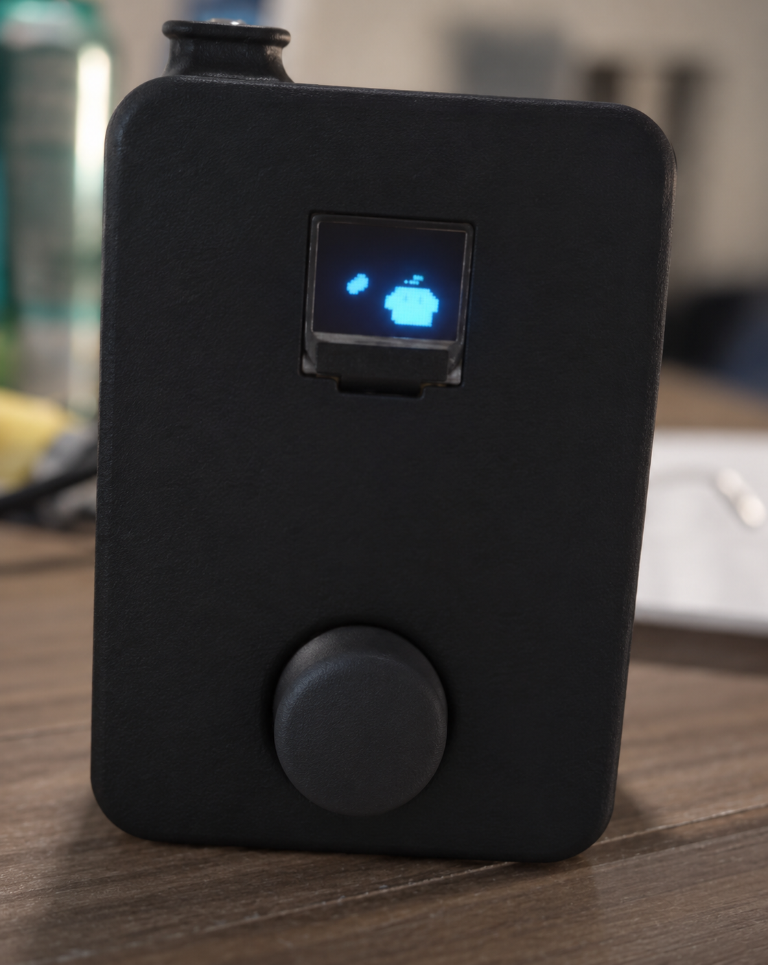 Johnny's black smart home Tomogatchi device with an OLED display and control knob